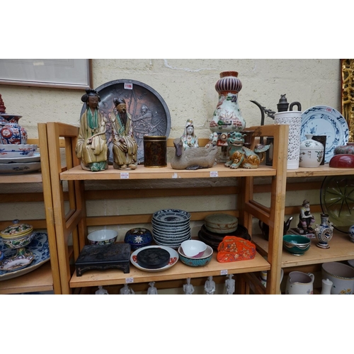 1106 - A mixed group of Oriental items. (2 shelves)