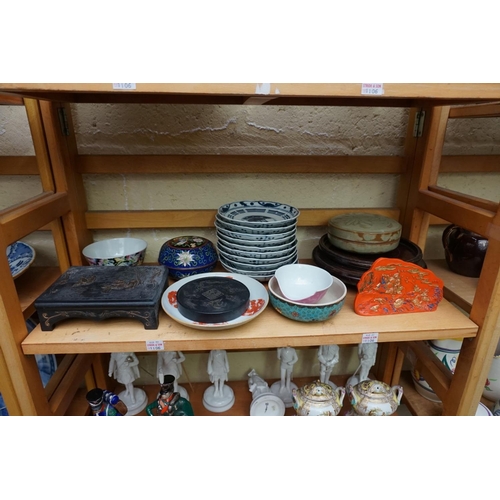 1106 - A mixed group of Oriental items. (2 shelves)