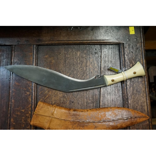 1760 - A large kukri and leather sheath, with ivory scales, 31cm blade.