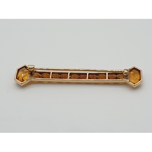 32 - (NB) An American Art Deco yellow metal bar brooch, set square and kite shaped citrines, stamped 14k,... 