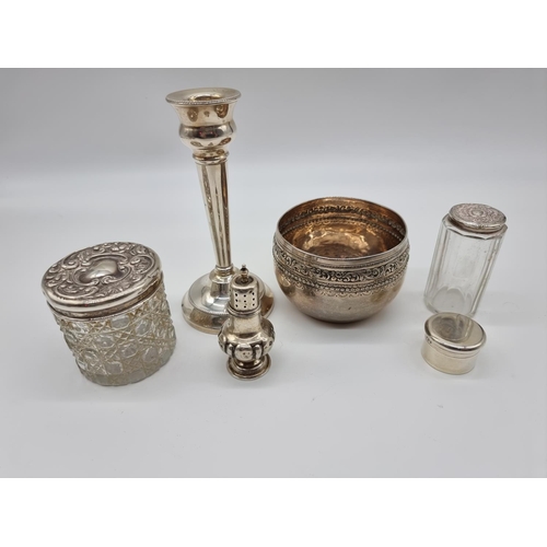 618 - A group of silver items, comprising; two silver lidded glass jars; a silver pill box; a silver candl... 