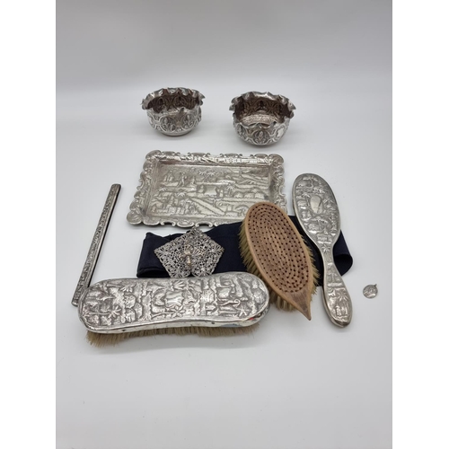 619 - A quantity of Eastern metalware; to include a pair of bowl and a four piece dressing table set. (7)... 