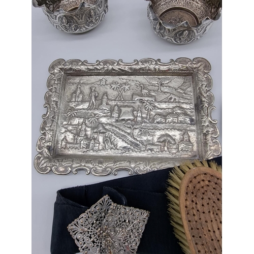 619 - A quantity of Eastern metalware; to include a pair of bowl and a four piece dressing table set. (7)... 