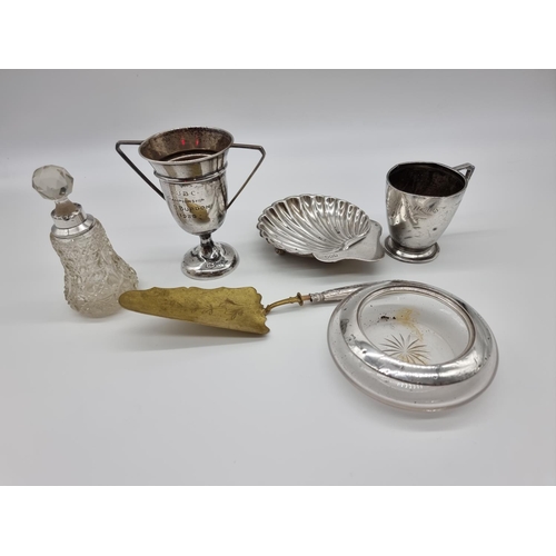 621 - A quantity of silver, to include: a silver shell shaped butter dish; a silver trophy cup; and a silv... 