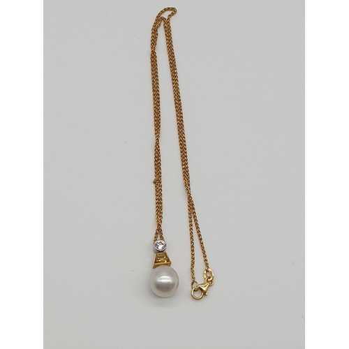 66 - (NB) A South Sea cultured pearl pendant, 11mm, suspended from a trapeze cut yellow diamond and a bri... 