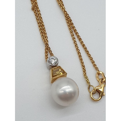 66 - (NB) A South Sea cultured pearl pendant, 11mm, suspended from a trapeze cut yellow diamond and a bri... 