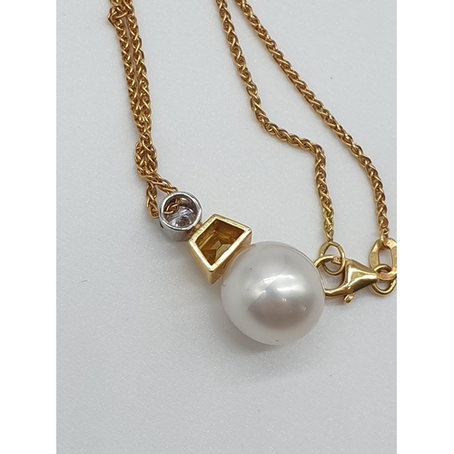 66 - (NB) A South Sea cultured pearl pendant, 11mm, suspended from a trapeze cut yellow diamond and a bri... 