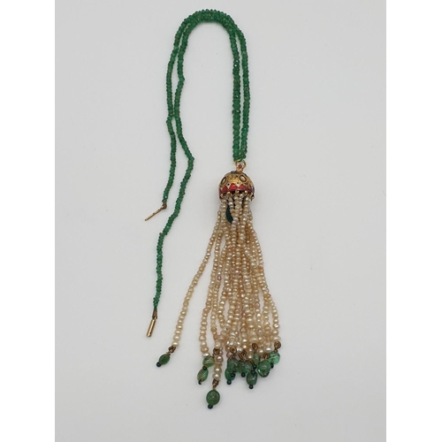 68 - (NB) An Indian yellow metal, enamel and gem set pendant, having seed pearl tassels on a faceted emer... 