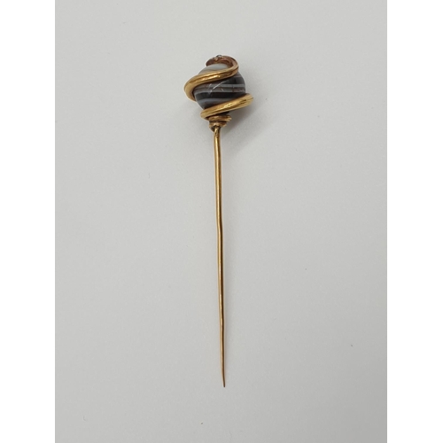 74 - (NB) A 19th century French yellow metal stick pin, terminating in an agate ball decorated coiled sna... 