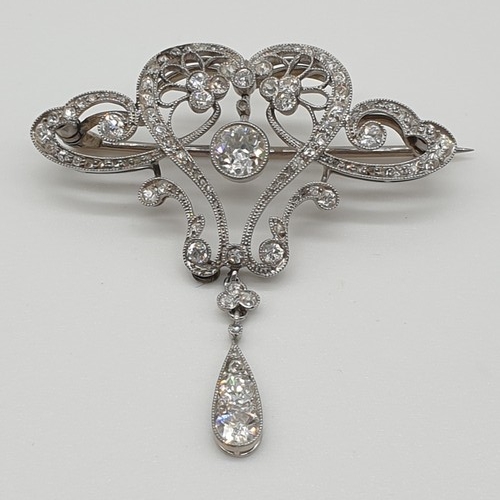 121 - (NB) An Edwardian Belle Epoque diamond set openwork brooch, having tear drop shaped drop, set approx...