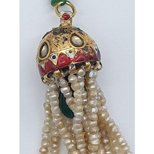 68 - (NB) An Indian yellow metal, enamel and gem set pendant, having seed pearl tassels on a faceted emer... 