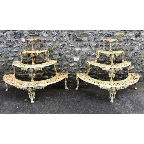 1717 - A pair of Victorian white painted cast iron four tier semi-circular plant stands, in the manner of C...