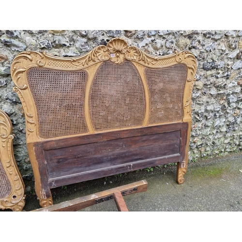 1032 - A carved giltwood and cane double bed, 152cm wide x 149cm high.