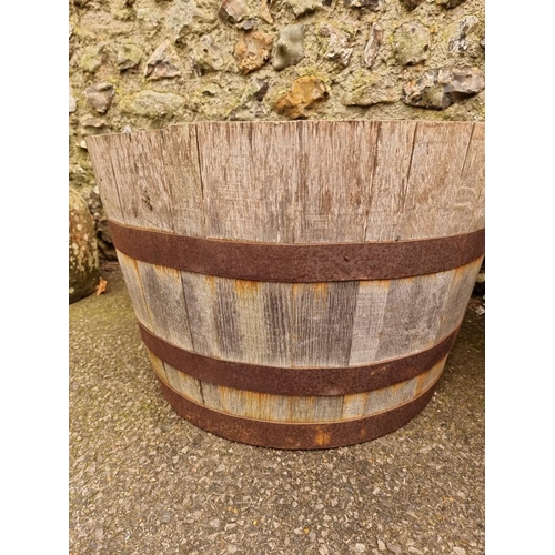 1043 - A pair of coopered wood and metal bound planters.