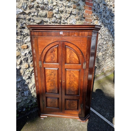 1076 - A Georgian mahogany corner cupboard, 140cm high x 90cm wide. 