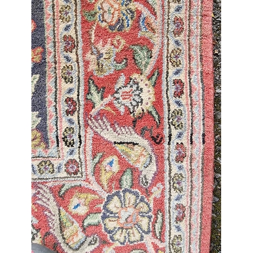 1145 - A Persian rug, central field decorated with two trees, parakeets, deer, rabbits and other exotic bir... 