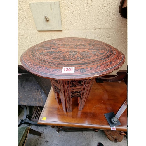 1201 - A red lacquer chinoiserie circular folding table, 46cm diameter. 