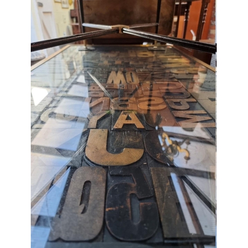 1250 - A vintage printing block rectangular low occasional table, the brass edged top inset with typeface o... 