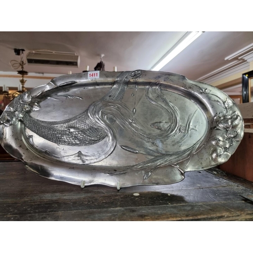 1411 - An Art Nouveau pewter tray, relief decorated with fish and scrolling waves, 56.5cm wide.  ... 