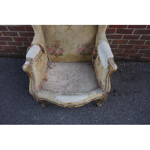 1469 - (ML) A late 19th century, Louis XV style, giltwood and upholstered wing armchair, with relief carved... 