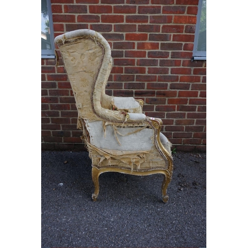 1469 - (ML) A late 19th century, Louis XV style, giltwood and upholstered wing armchair, with relief carved... 