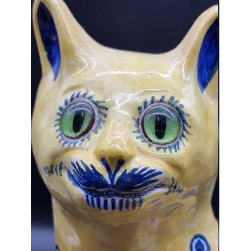 1603 - (ML) A Mosanic pottery cat, painted with blue hearts on a yellow ground, 31cm high. ... 