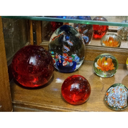 1659 - Twenty-six glass paperweights, to include examples by Caithness.