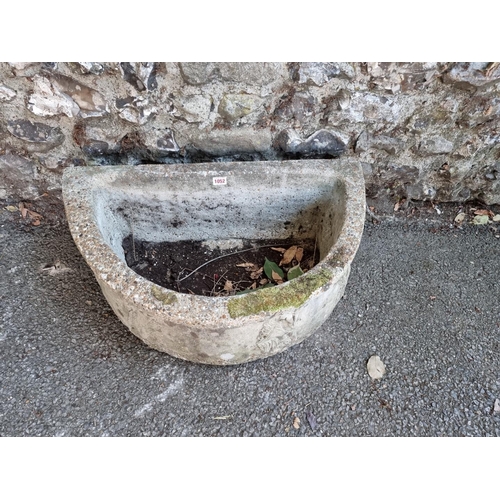 1052 - A reconstituted half moon garden trough, 68cm wide.