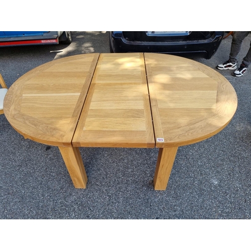 1072 - A contemporary oak 'Charltons' extending dining table; together with four matching chairs.... 