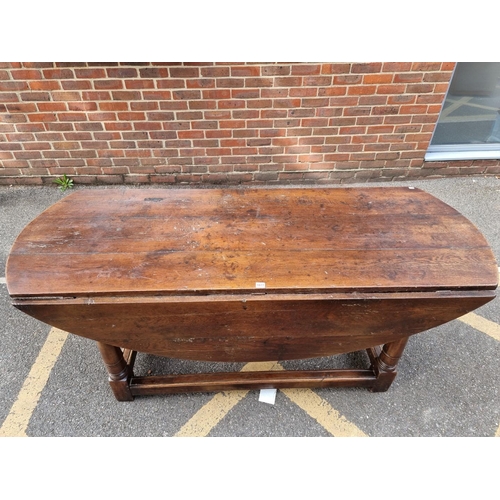 1077 - An antique oak dropleaf dining table, 184cm wide. 