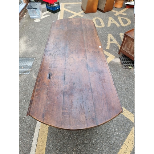 1077 - An antique oak dropleaf dining table, 184cm wide. 