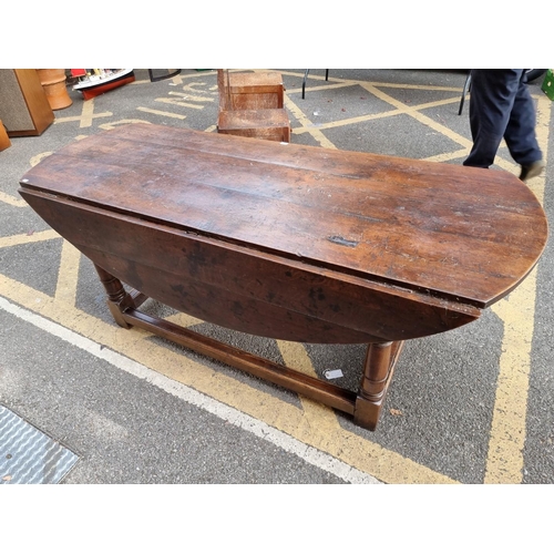 1077 - An antique oak dropleaf dining table, 184cm wide. 