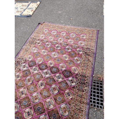 1093 - A Khyber Bokhara rug, having repeated central field on purple ground, 188cm x 98cm.