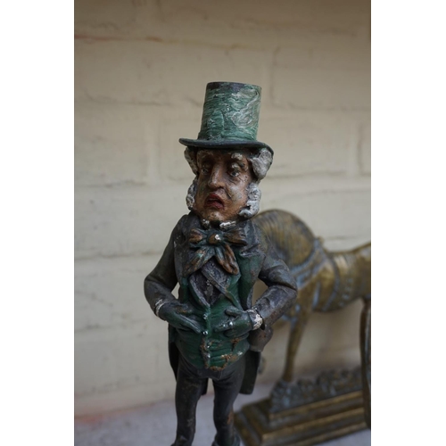 1234 - A polychrome painted metal novelty Mr Micawber candlestick, 33cm high.