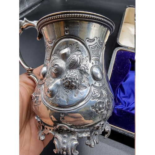 561 - A cased Victorian silver mug, by Daniel & Charles Houle, London 1865, having chased and embossed... 