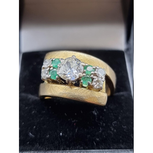 684 - A yellow metal diamond and emerald cocktail ring, set central diamond of approximately 1ct, with fou... 