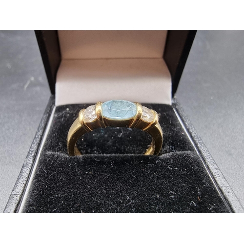 700 - An 18ct gold ring, set central oval facetted aquamarine and two brilliant cut diamonds, each of appr... 