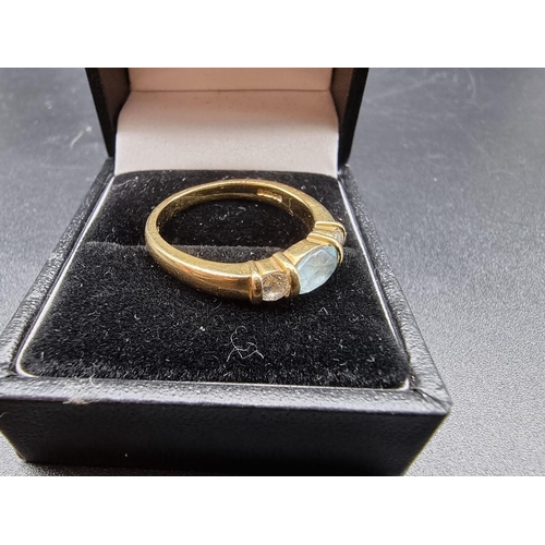 700 - An 18ct gold ring, set central oval facetted aquamarine and two brilliant cut diamonds, each of appr... 