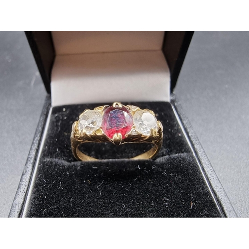 703 - A yellow metal garnet and diamond three stone ring, stamped 18ct, size O, gross weight 3.9g.(please ... 