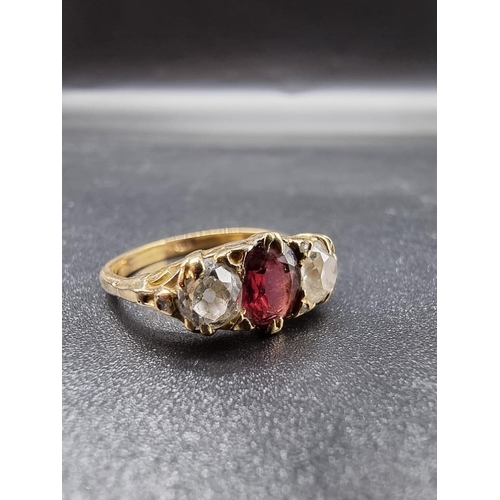 703 - A yellow metal garnet and diamond three stone ring, stamped 18ct, size O, gross weight 3.9g.(please ... 