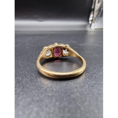 703 - A yellow metal garnet and diamond three stone ring, stamped 18ct, size O, gross weight 3.9g.(please ... 