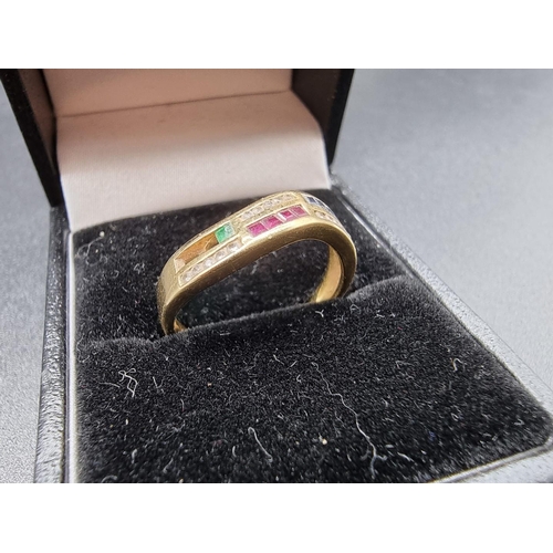 729 - A yellow metal ring, channel set with diamonds, rubies, emeralds and sapphires, size O1/2, gross wei... 