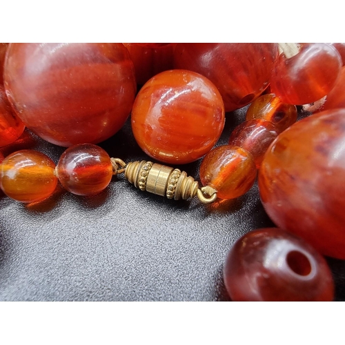 802 - An amber style graduated bead necklace.