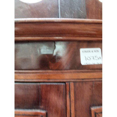 1075A - An Edwardian mahogany bowfront standing corner display cabinet, having two pairs of ebony strung ast... 