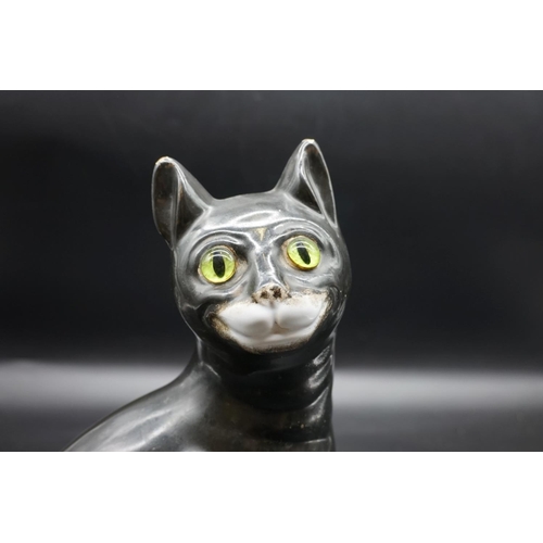 1590 - A Galle black glazed faience cat, signed, with green glass eyes, 36cm high, (s.d).