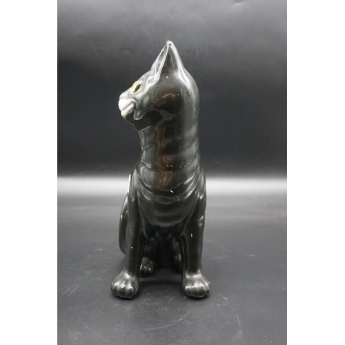 1590 - A Galle black glazed faience cat, signed, with green glass eyes, 36cm high, (s.d).