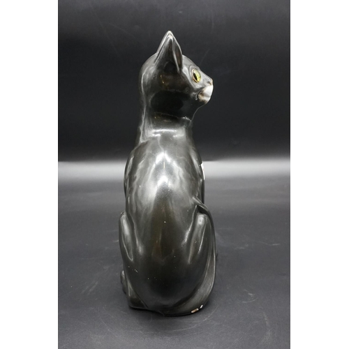 1590 - A Galle black glazed faience cat, signed, with green glass eyes, 36cm high, (s.d).