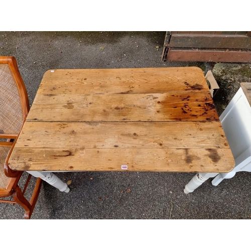 1028 - An antique pine kitchen table, having one drawer and white painted legs, 120cm wide x 83cm deep x 74... 