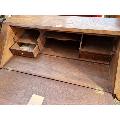 1035 - A continental carved oak bureau, 80cm wide x 43cm deep x 95cm high.