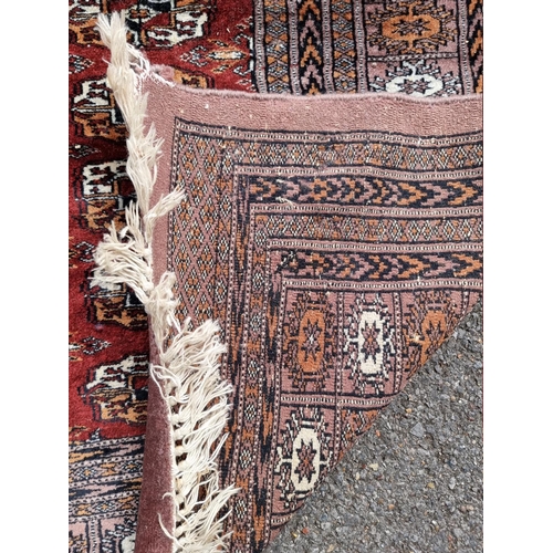 1059 - A Bokhara rug; together with a smaller example. 